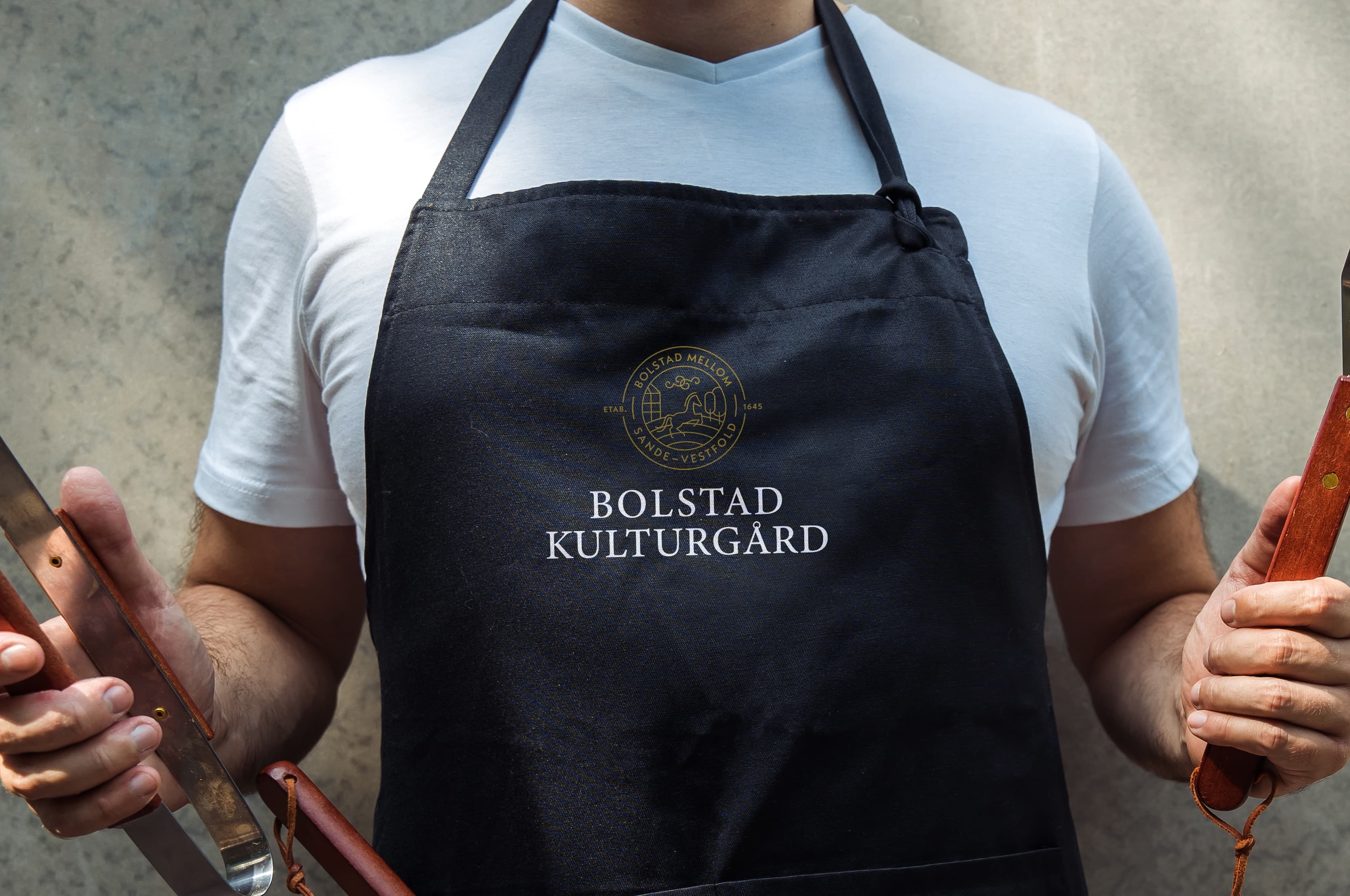 Kokk på Bolstad Kulturgård med forkle — lokale råvarer fra gården